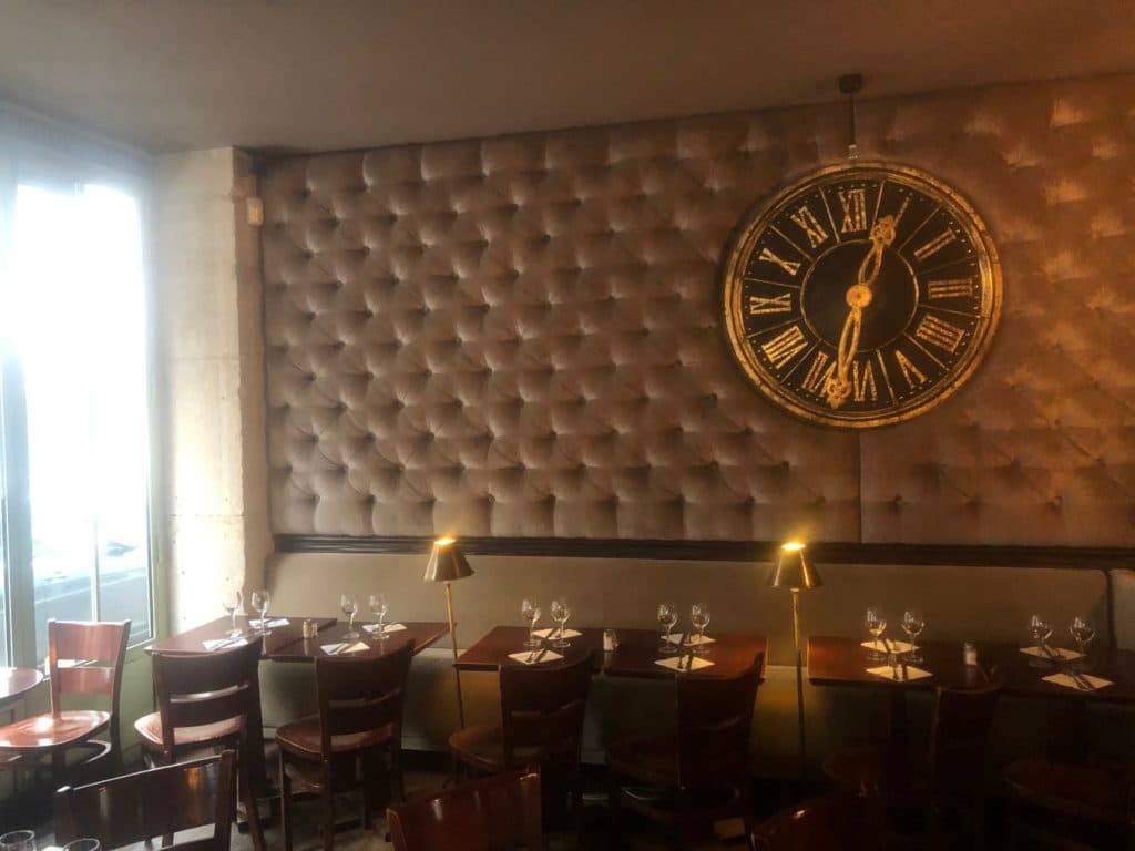 Salle de brasserie avec banquettes et horloge
